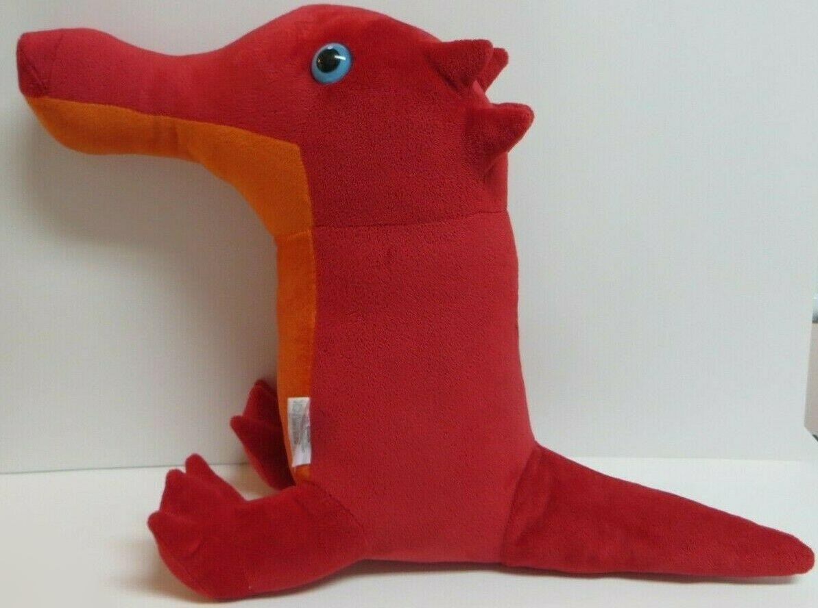 A photograph of a plush toy of a nakodile from Homestuck, a red crocodile creature with no arms, blue eyes, and an orange underbelly.
