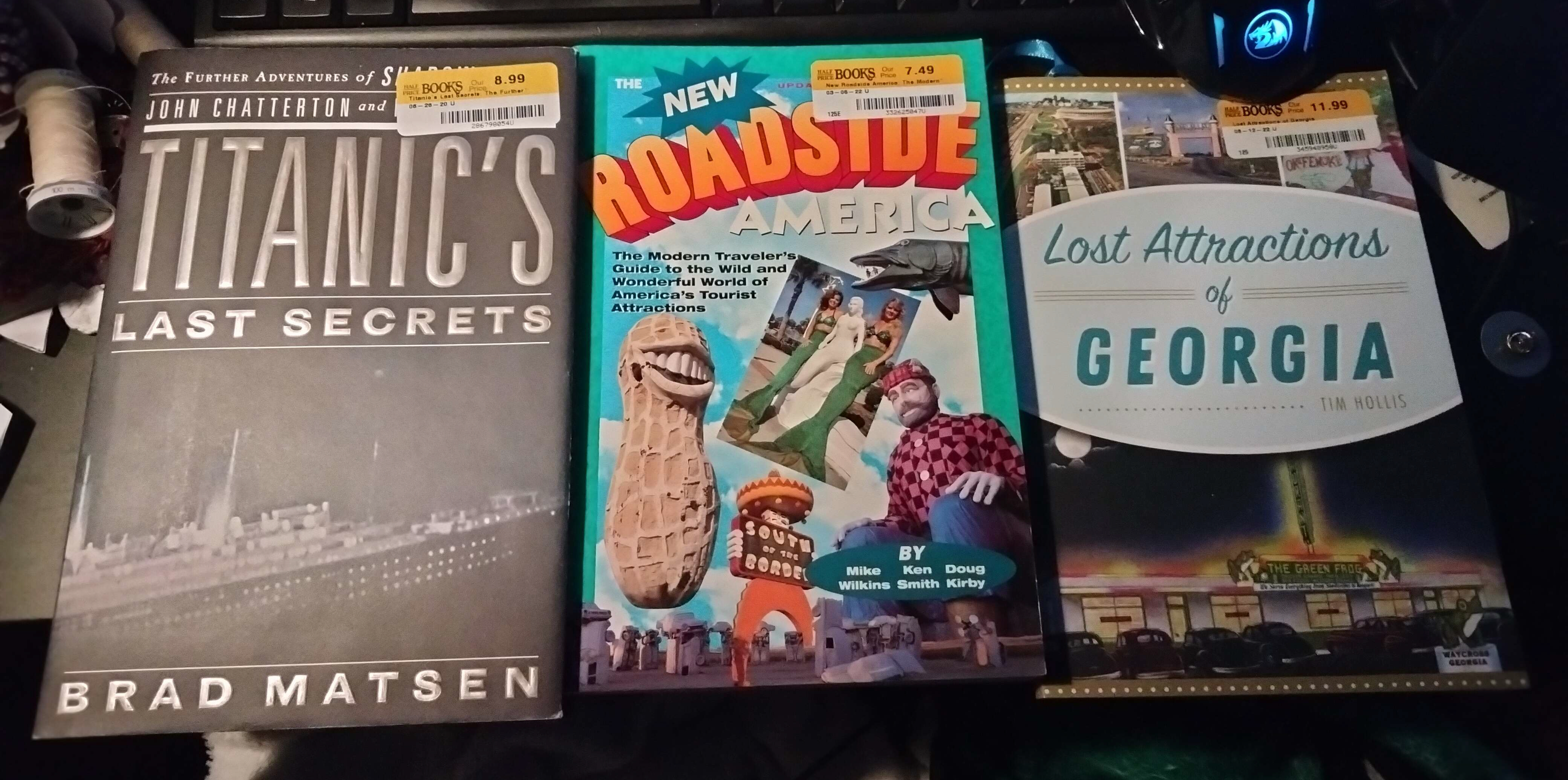 A photograph taken on a desk that shows off three books: New Roadside America, Lost Attractions of Georgia, and Titanic's Last Secrets.