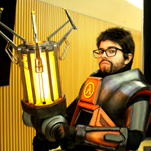 A photograph of the webmaster, Elliot, dressed up as Gordon Freeman from Half Life. He holds the viewer's gaze with a neutral stare in his HEV suit and a gravity gun in his raised hands.